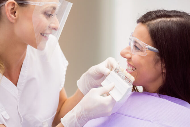 uma dentist mostrando para uma mulher dentes e tonalidades para lente de contato dental em curitiba